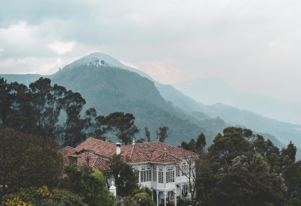 Charming Casa Santa Clara nestled in lush Colombian mountains with misty landscape.