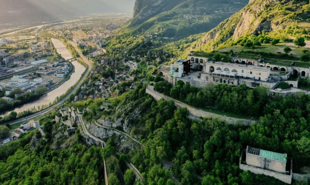 Stunning aerial view of Grenoble cityscape and surrounding mountains at sunset.